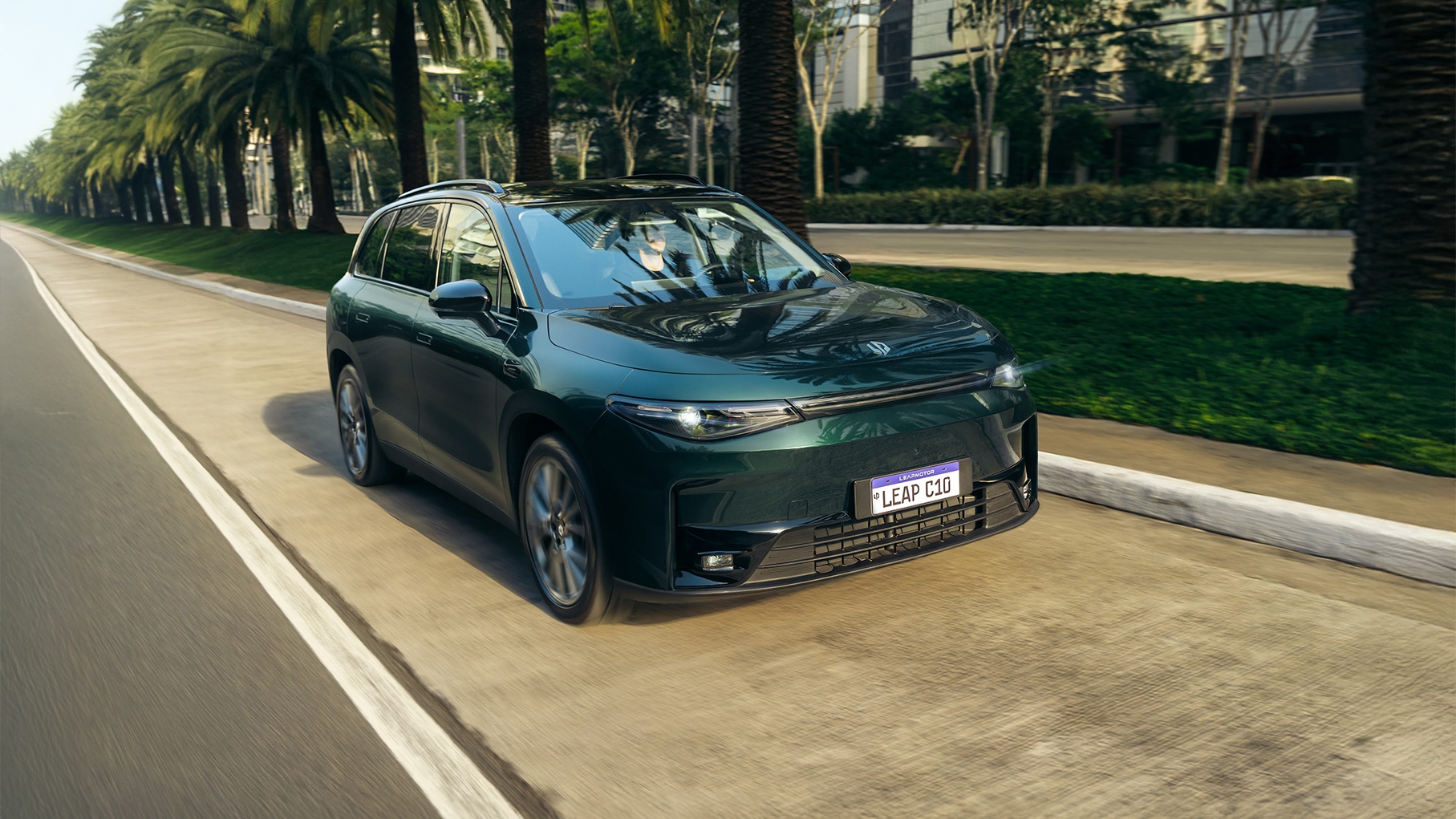 Dark green Leapmotor C10 SUV driving along a palm lined boulevard, shown from the front three quarter angle.