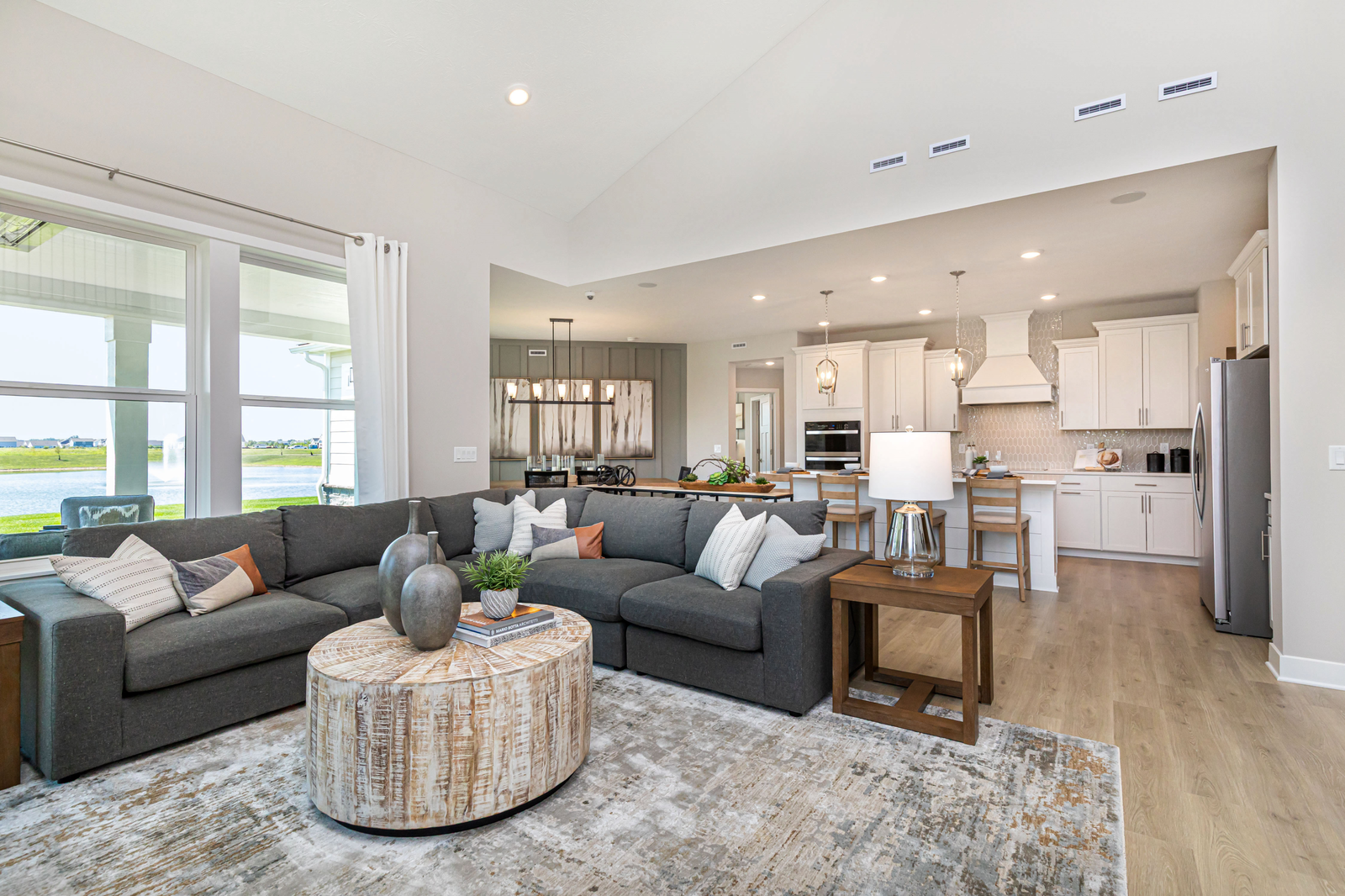 open-concept great room with grey sectional and floor-to-ceiling windows