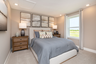 secondary bedroom with steel blue bedding and neutral decor