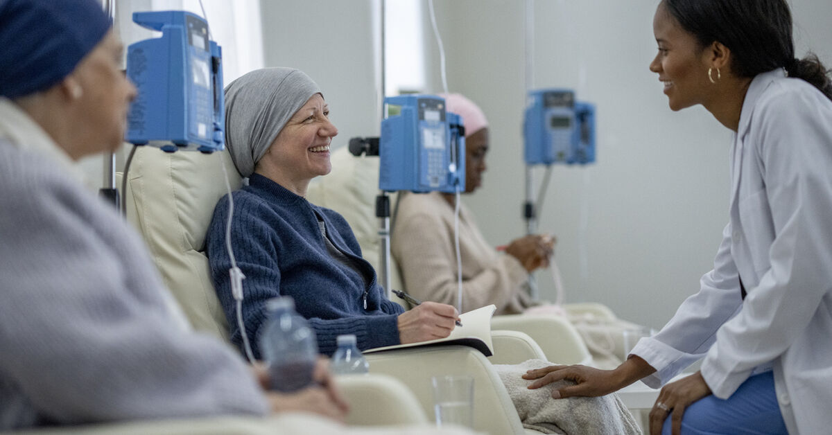 Doctor visiting patient receiving chemo in infusion center