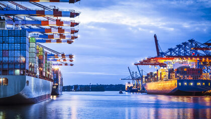 Cargo ships in port at sunset