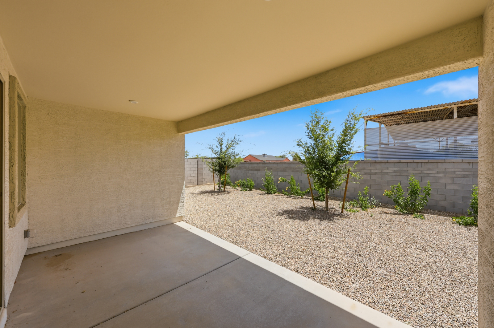 spacious covered patio with recessed lighting and views of the landscaped backyard with trees