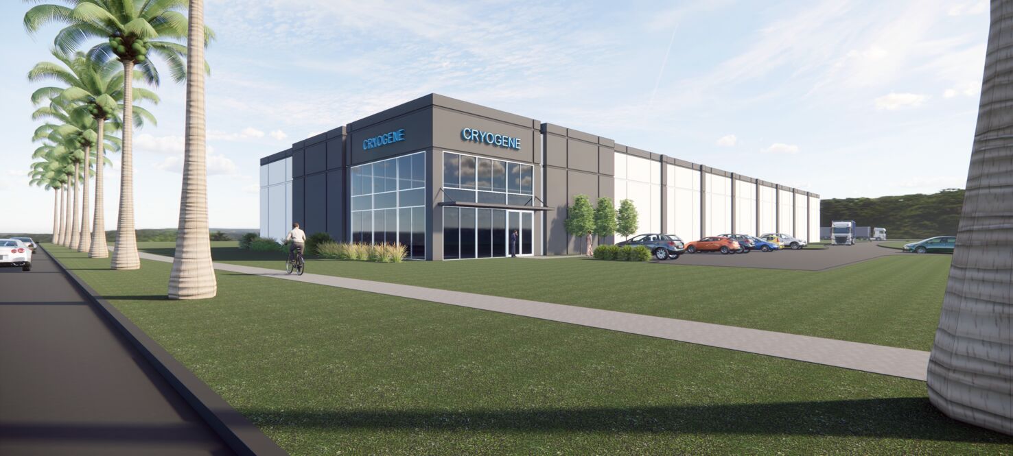 A square-shaped, one-story building is surrounded by grass and palm trees.