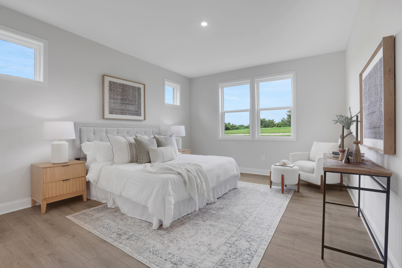 primary bedroom with windows and hard surface floors