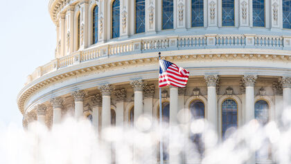 Close up of the Capitol Hill building with an American flag waving in front of it