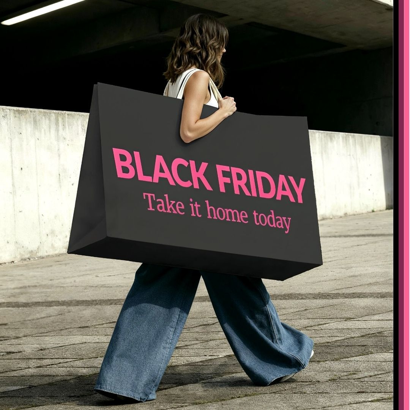 Lady walking with oversized bag that says Black Friday Take it Home Today