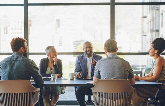 Diverse group of people in a conference room sitting at a long table