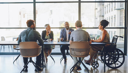 Diverse group of people in a conference room sitting at a long table