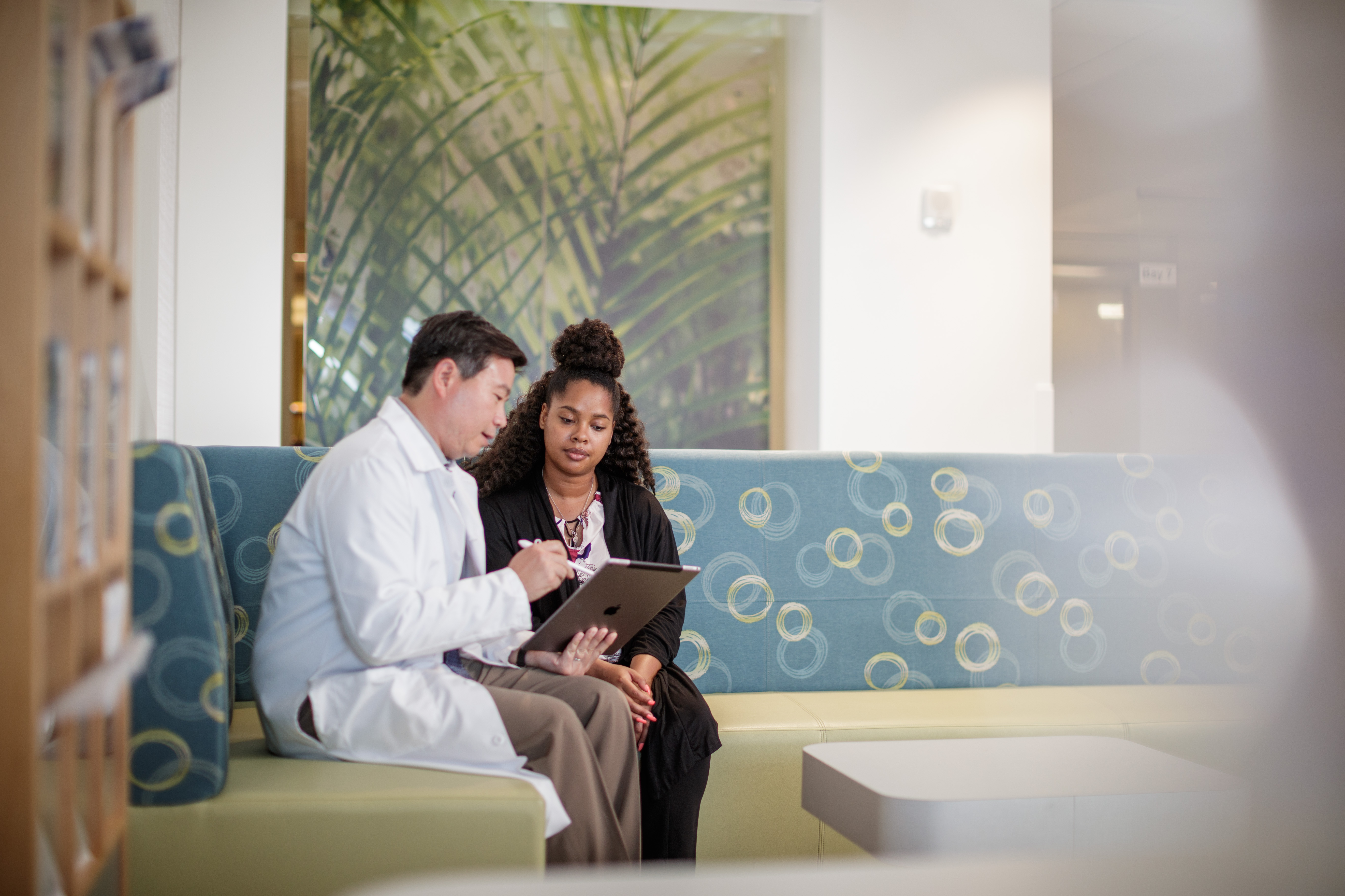 Doctor consulting patient while sitting on couch