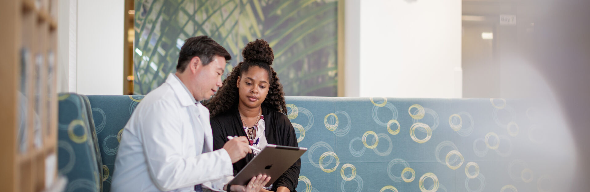 Doctor consulting patient while sitting on couch