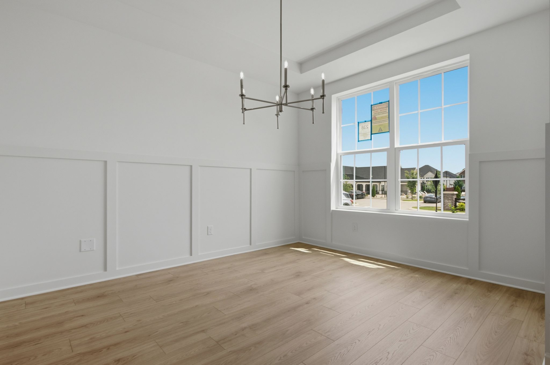 dining room with large windows, light wood floors and an accent chandelier