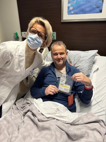 Photo of Dr. Druta with patient JP Malherbe holding his bag of Tecelra Cells