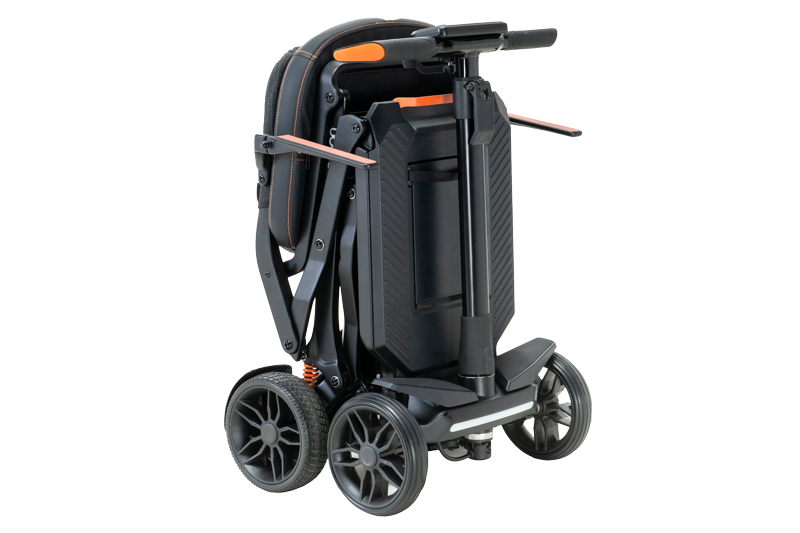 A lightweight, foldable mobility scooter in a compact upright position. The scooter has four wheels, a black and orange frame, and a telescopic handle for easy transport. Its sleek design features modern detailing and a sturdy base.