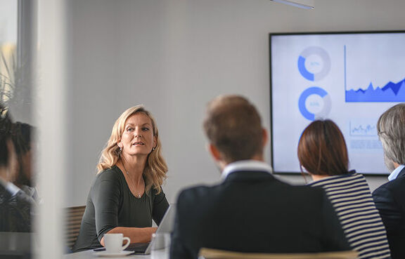 group of professionals attending a meeting with a slide show