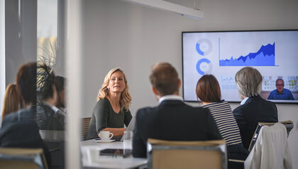 group of professionals attending a meeting with a slide show