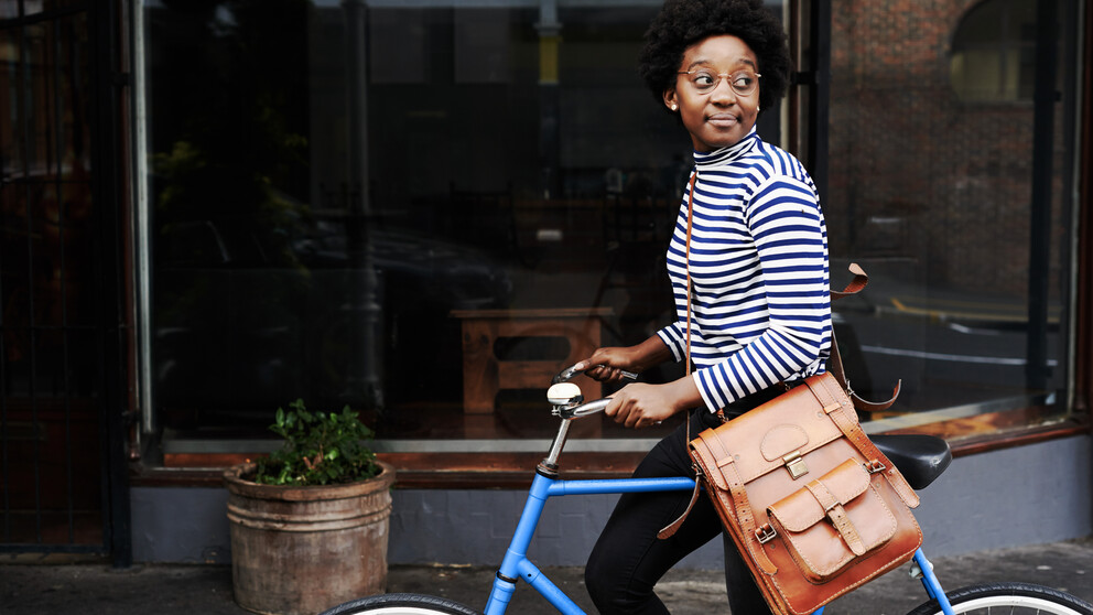 Dame mit Brille auf einem blauen Fahrrad
