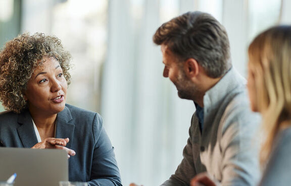 Female insurance agent talking to a couple at her desk