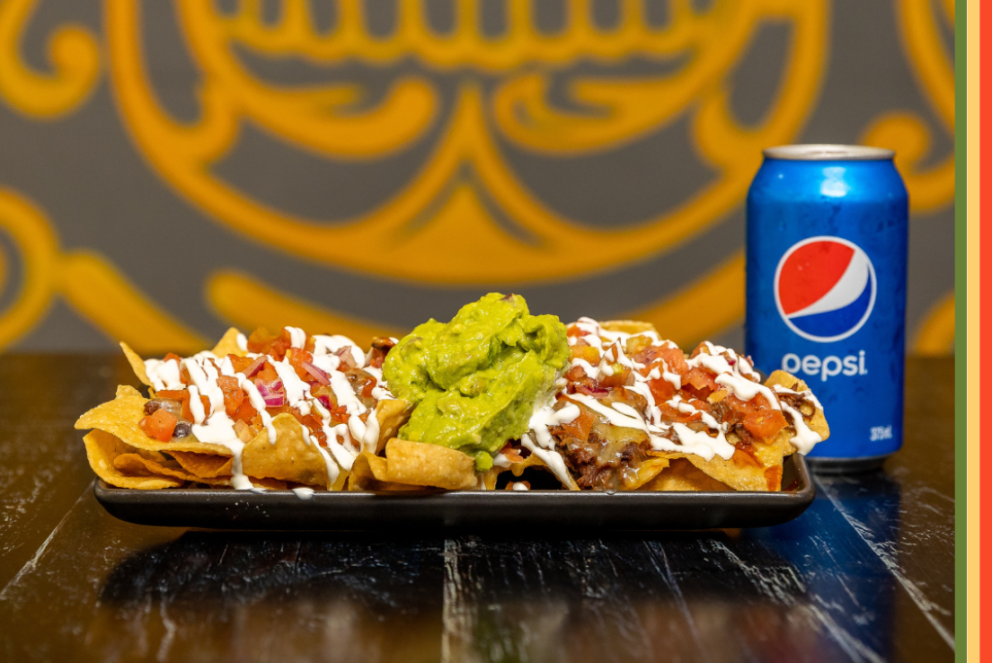 Plate of nachos with a can of Pepsi from Burrito Bar