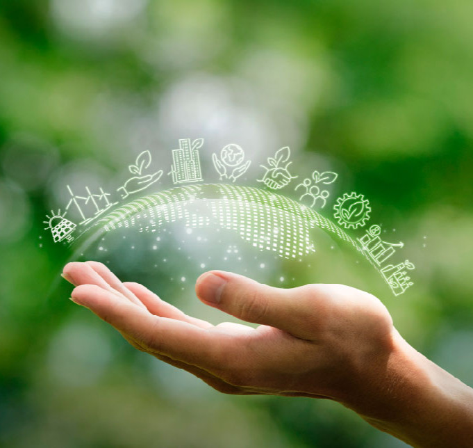 Close up of hand showing several symbols, including solar panels, windmills, a globe, and more. Hand shown on a background of greenery / nature. Image symbolises environmentalism and ethics