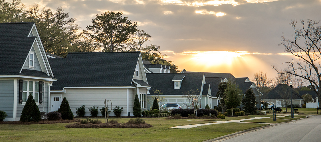 A neighborhood street with a row of nice houses 