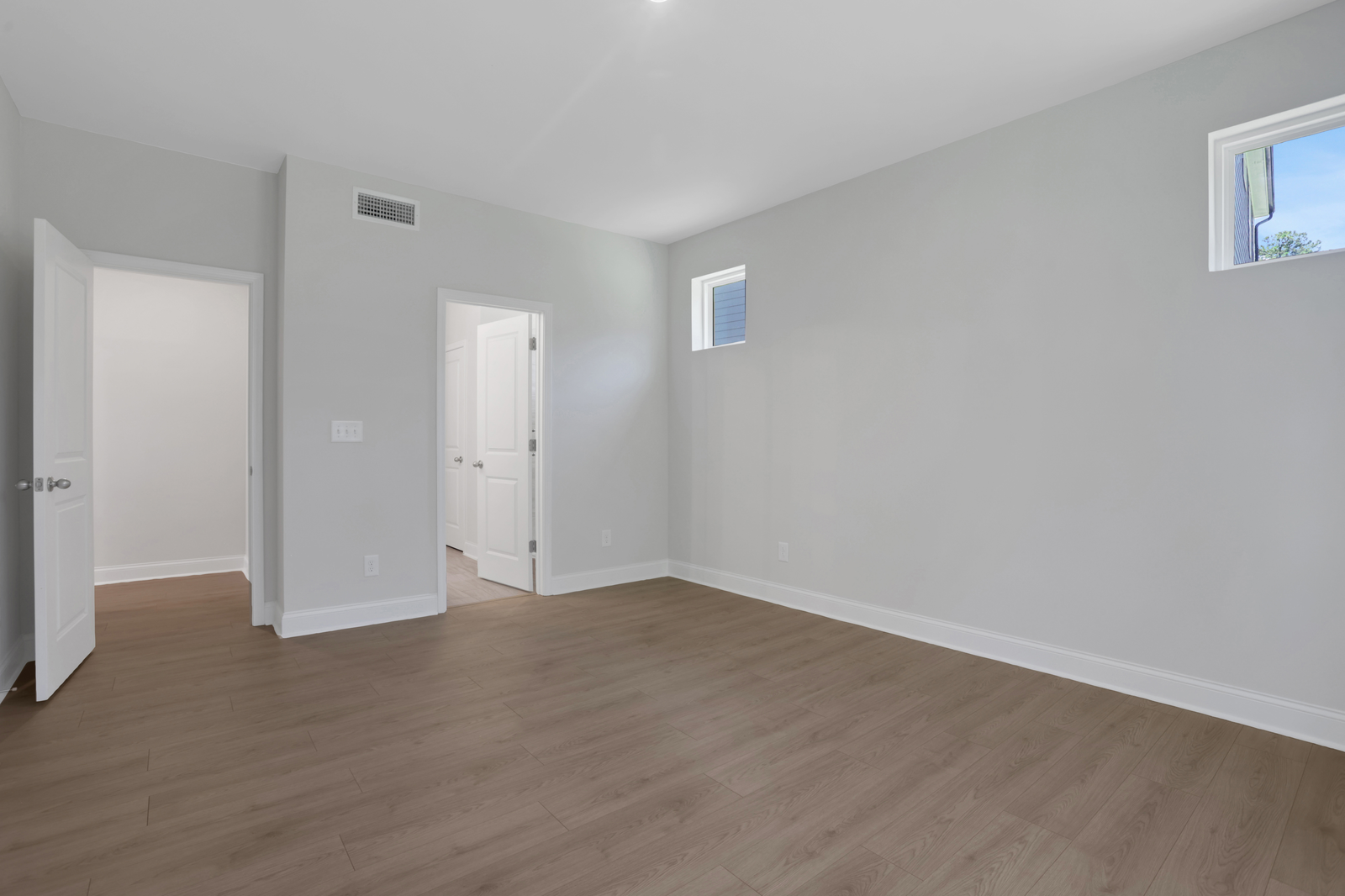 primary bathroom with white cabinets and tile flooring 