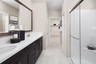 primary bathroom with white countertops and neutral tile floors
