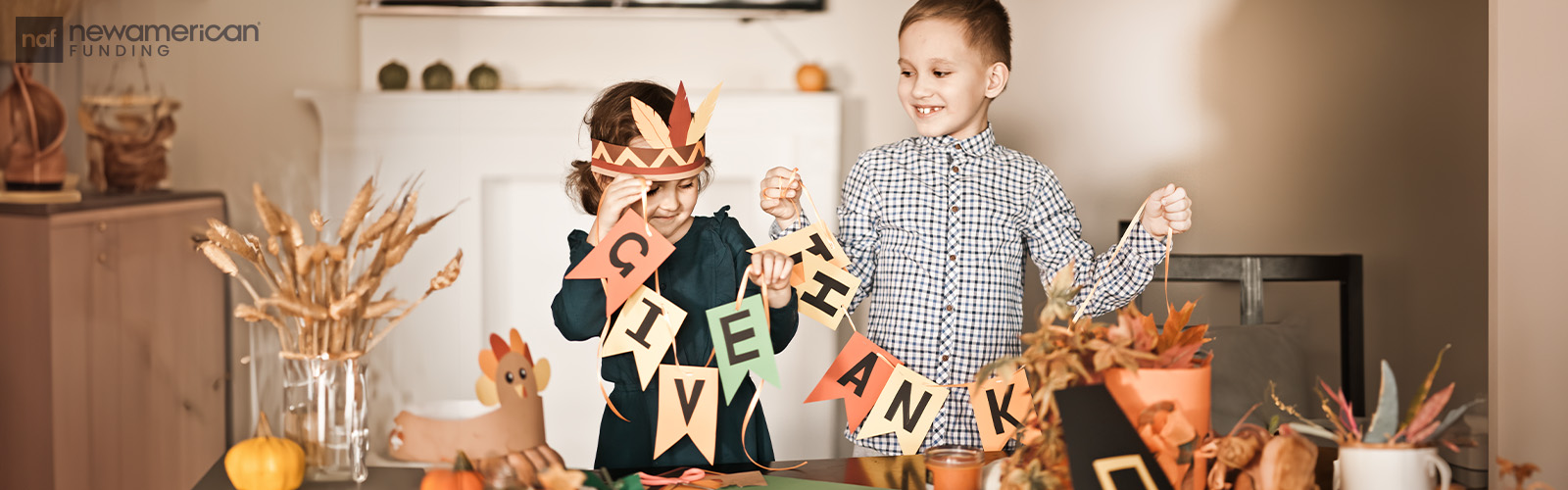 Two children unwrap a garland that says 