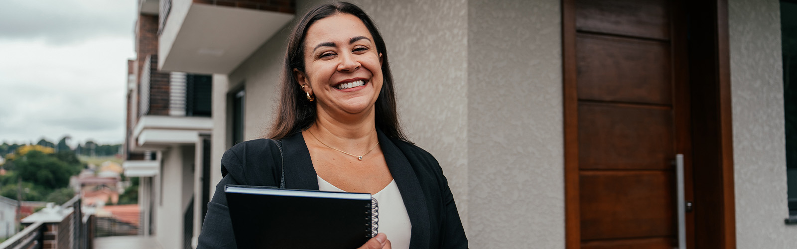 A smiling woman holding paperwork