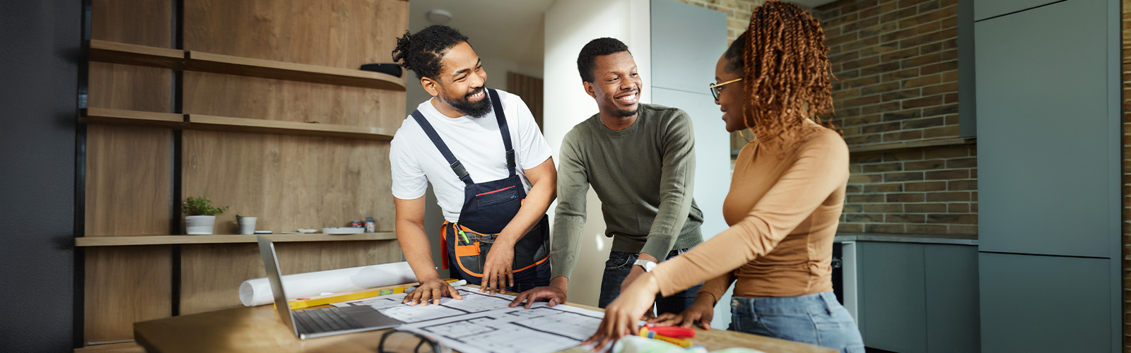 Couple looking at blueprints with contractor