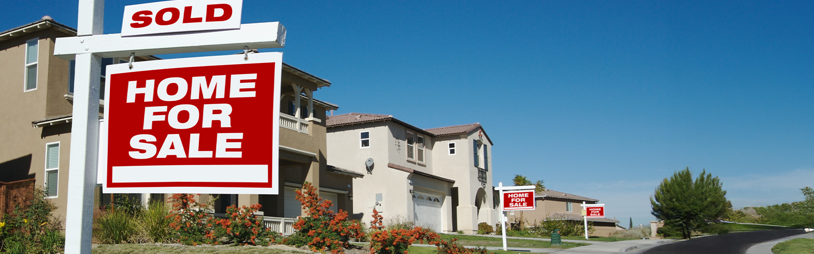 For sale signs in front of homes