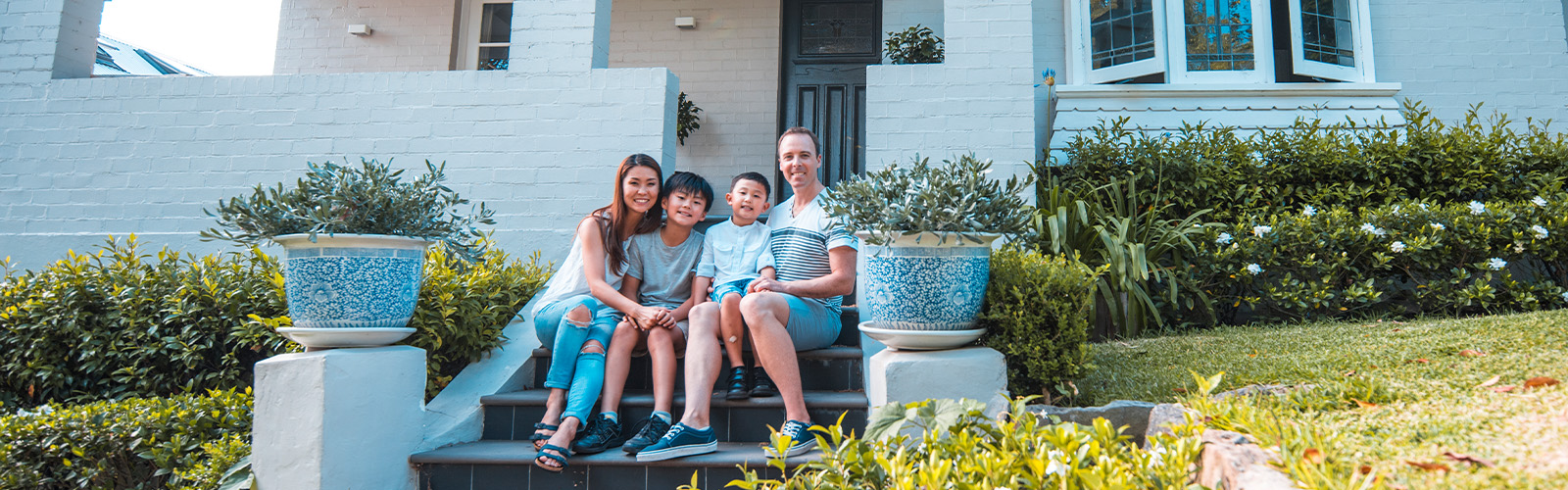 A happy family sitting on their front porch