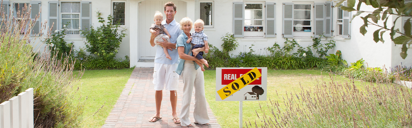 A family standing in front of their new home