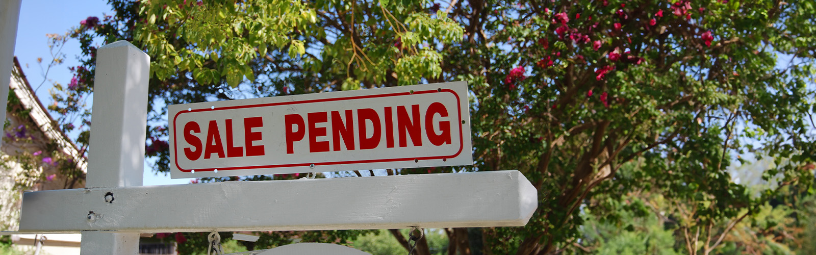 A sale pending sign in front of a home