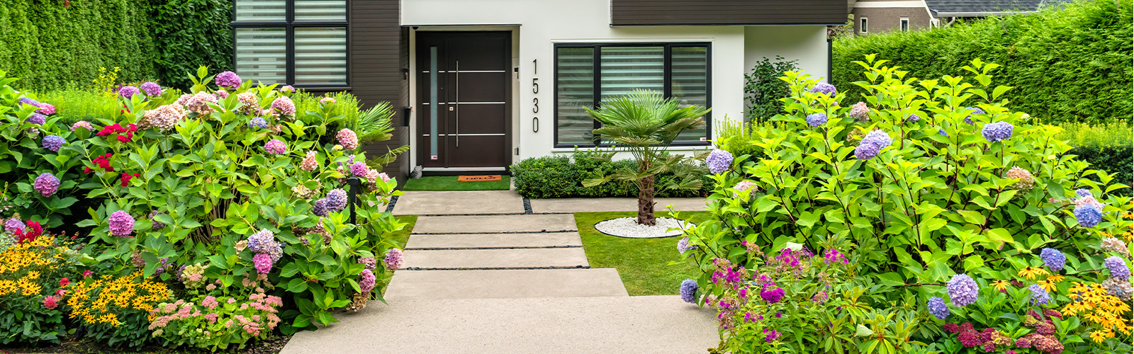 A modern home with flowers in front