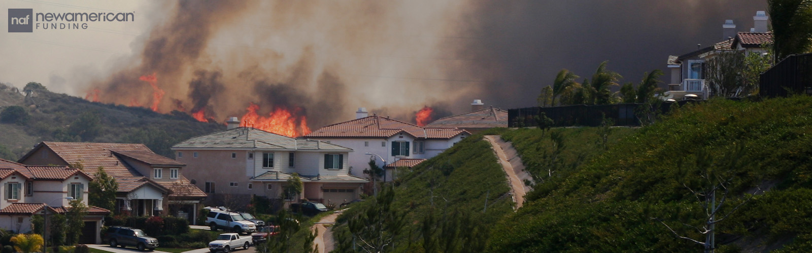 A wildfire burns on a hillside over a neighborhood