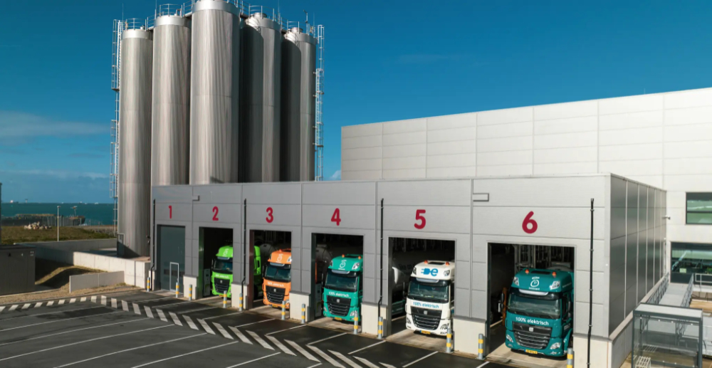 A photo of a loading bay at the back of a factory or warehouse with 6 parking bays for lorries and lorries in 2 to 6 