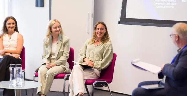 Women sat on a panel with a man with a clipboard asking questions 