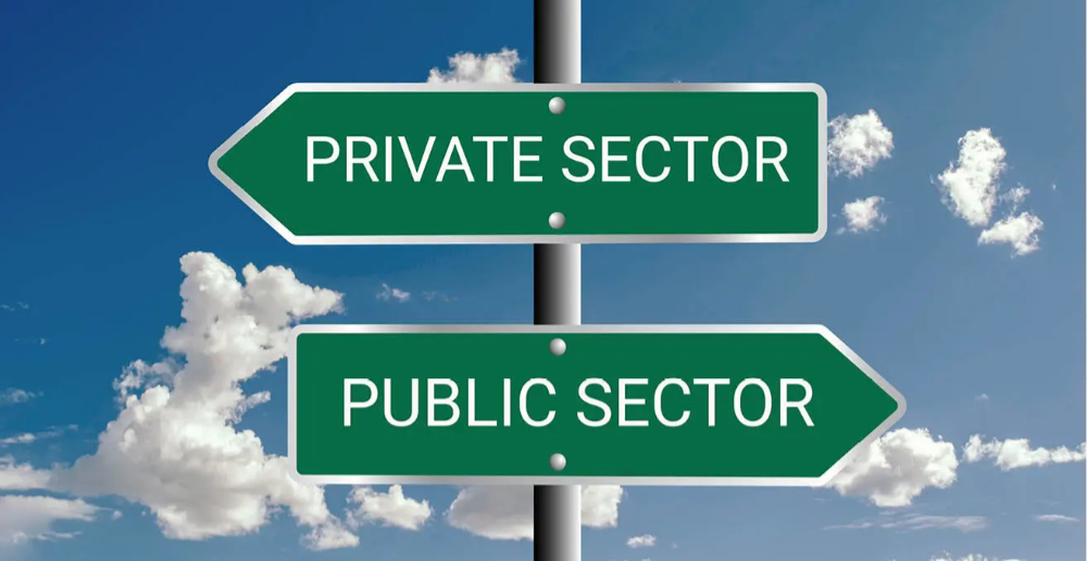 A green signpost with "Private Sector" at the top pointing left and "Public Sector" below pointing right