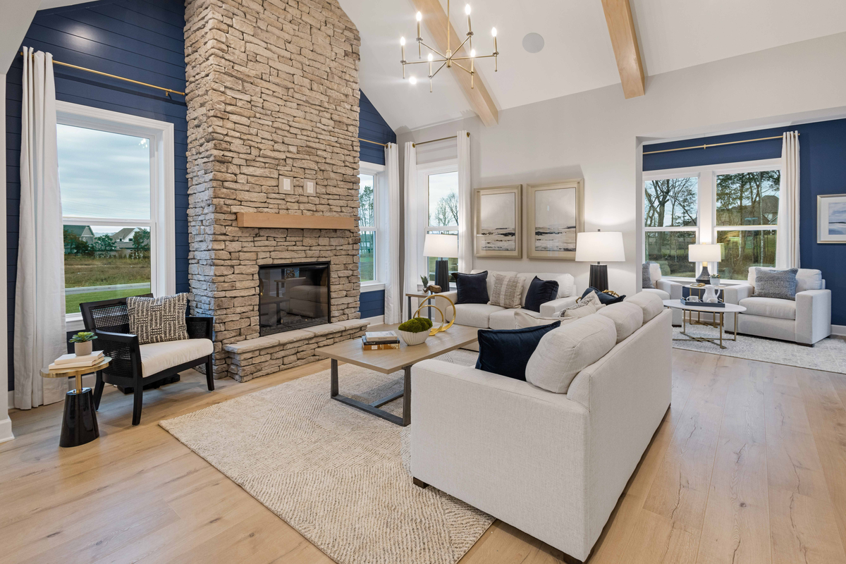 great room with stone fireplace and wood floors
