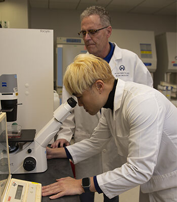 Senior research specialist Vincent Law examines a sample under a microscope in Forsyth&rsquo;s lab. Researchers are working to better understand how leptomeningeal disease works and how to boost the immune response to it.
