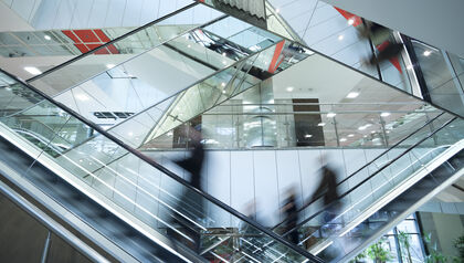 Blurred figures riding on an escalator