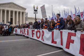 College students carry the March for Life banner past the U.S. Supreme Court building.