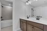secondary bathroom with wood cabinets and tile flooring