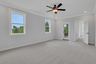 primary bedroom with windows and carpet