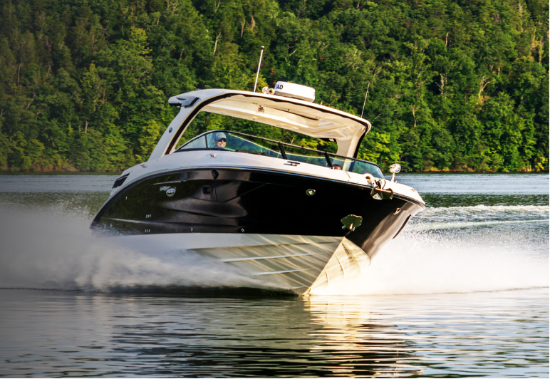 Black and white powerboat with onboard Fathom e-power system makes turn on a lake