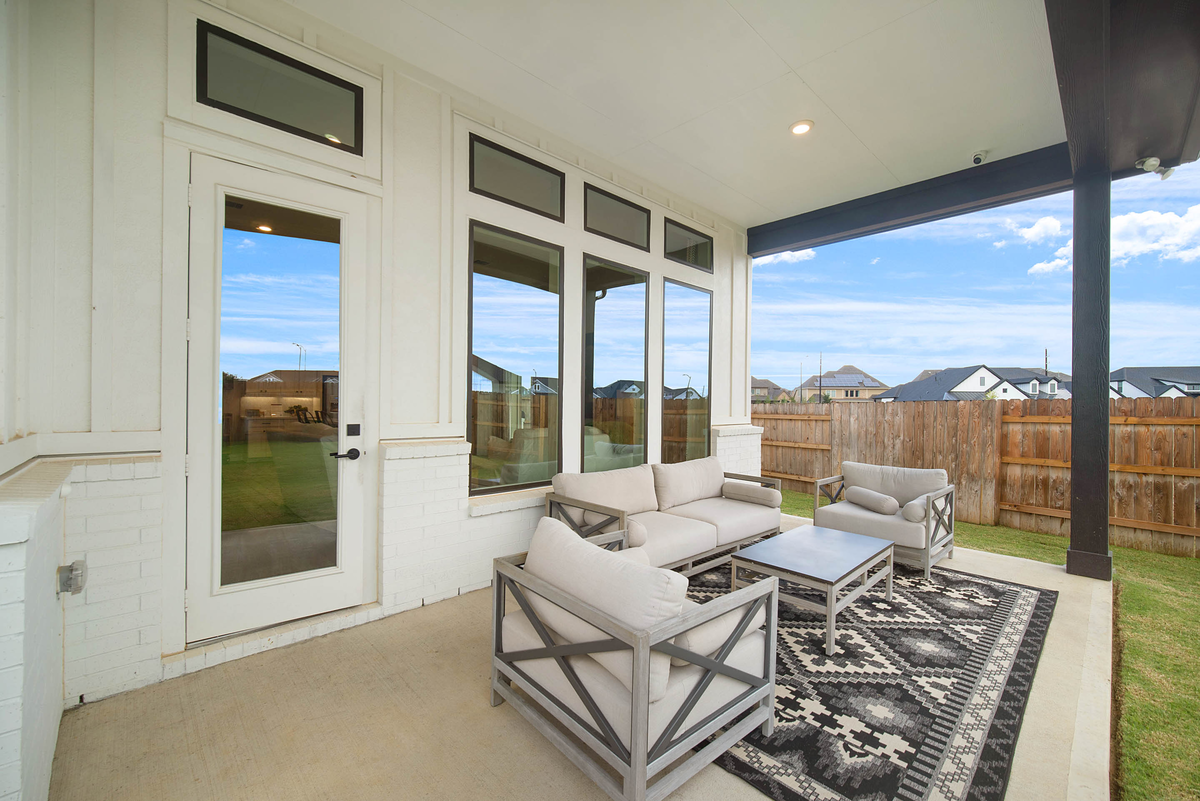 covered back patio with plush lawn
