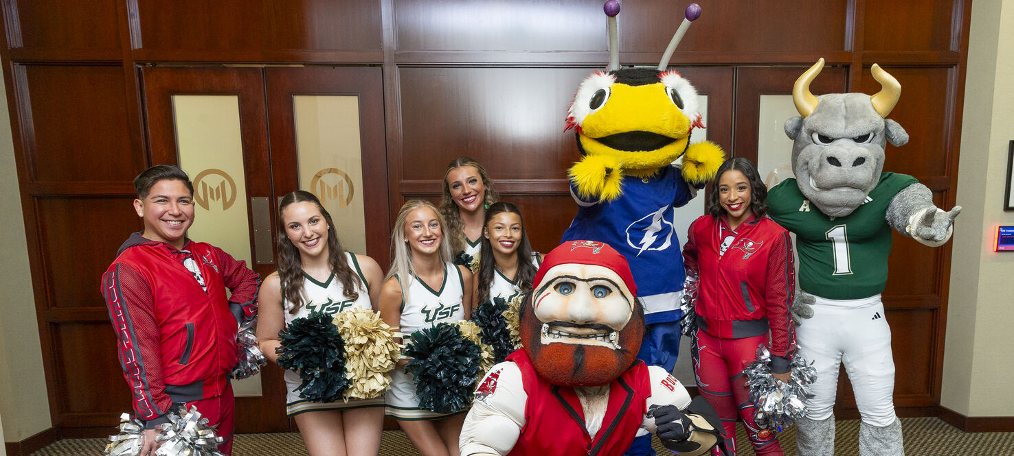 Moffitt patients and team members pose for photos with Tampa Bay sports team mascots and cheerleaders.