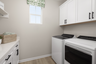 laundry room with neutral floors and window