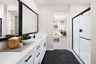 primary bathroom with dark flooring and white countertops