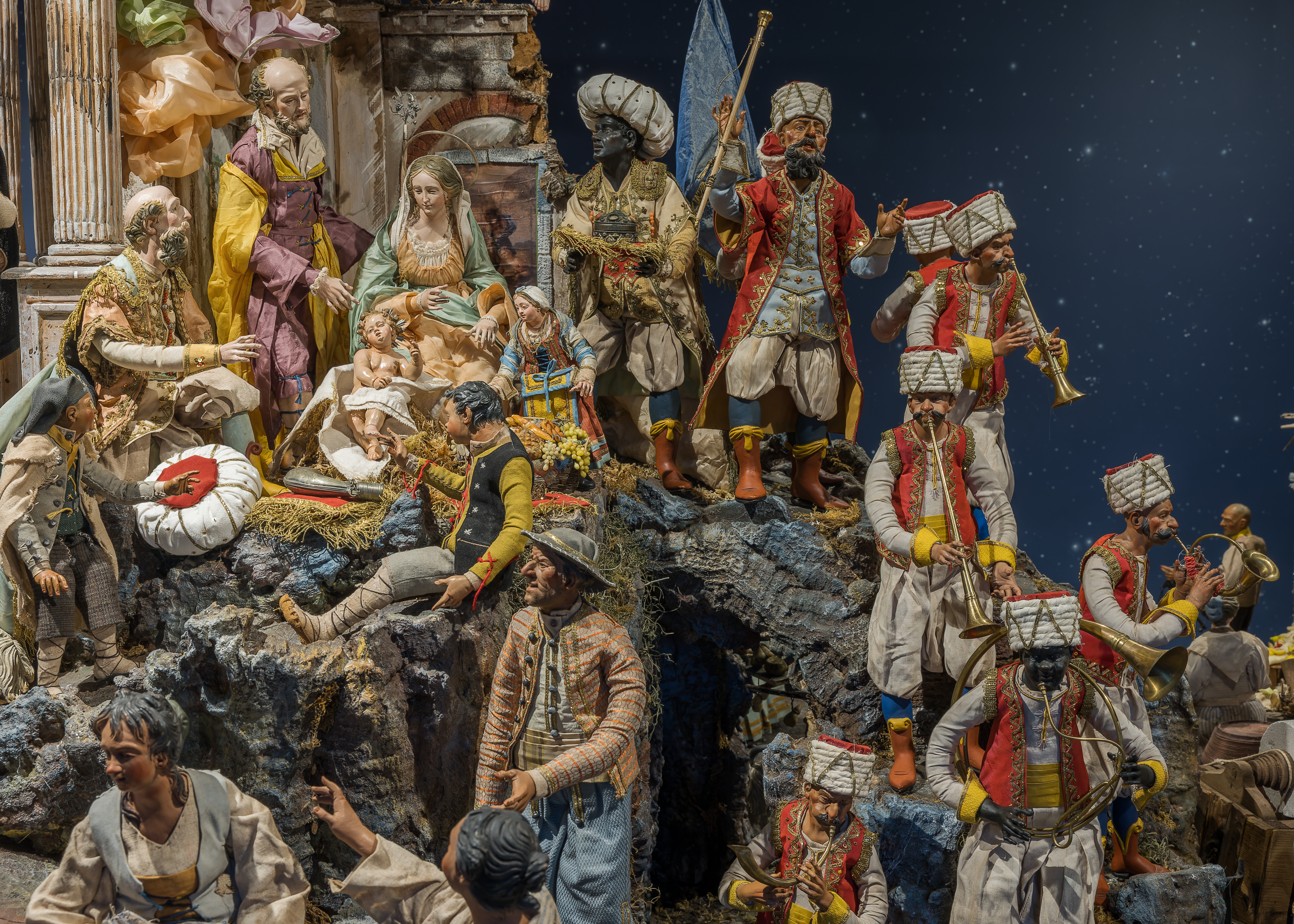 Detail photo of shows center of the Nativity with the Roman ruins, Holy Family, 2 Magi band, and local people of 16th century Neapolitan society.